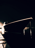 Yacht privé à quai la nuit, reflets champagne sur l'eau noire