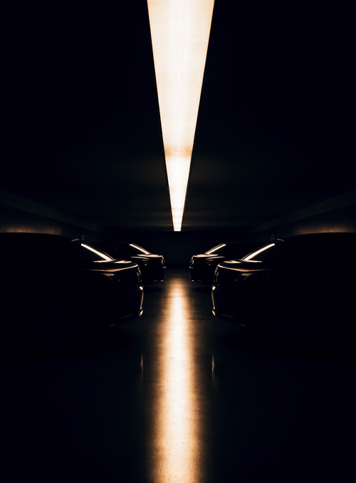 Garage privé souterrain, rangée de voitures sombres sous un bandeau lumineux