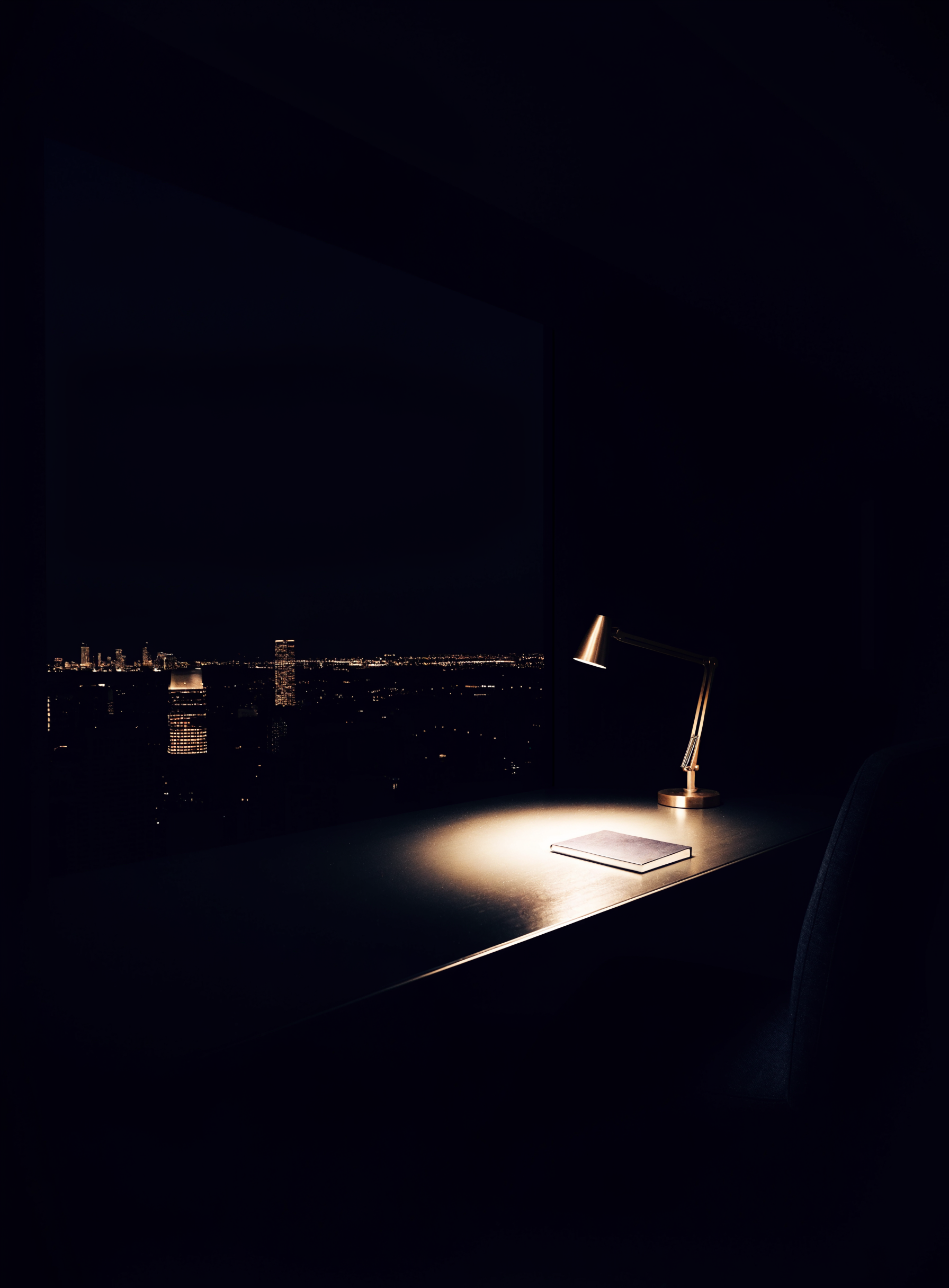 Bureau de penthouse la nuit, skyline lointain, lampe en laiton