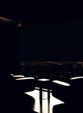 Deux fauteuils noirs face à une baie vitrée de penthouse, ville la nuit